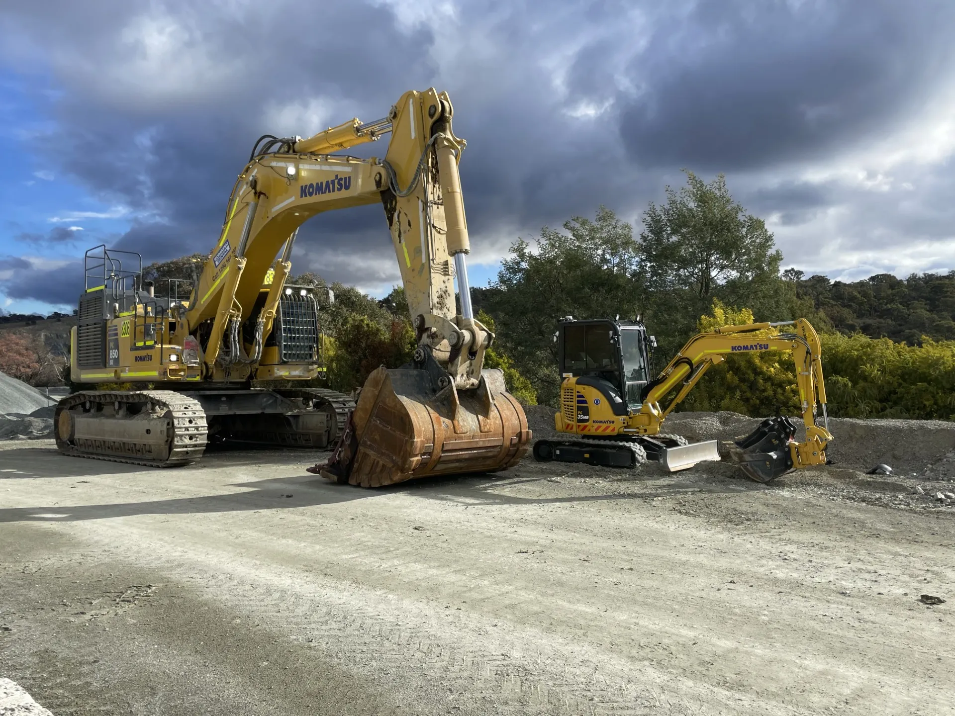 Komatsu excavators parked on a gravel site in the Canberra region